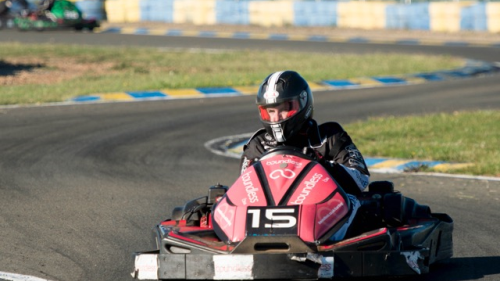 Red kart number 15 racing around the track